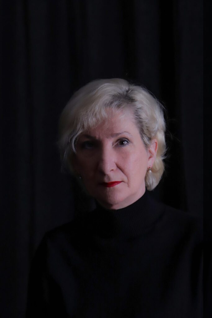 Portrait einer Frau mit blond en Haaren auf dem schwarzen Hintergrund